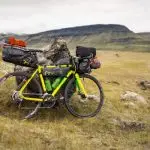 A fully loaded bike rests against rocks in Iceland's rugged highlands, perfect for expedition travel.
